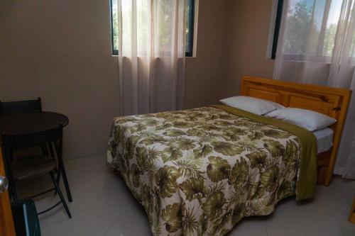 - une chambre avec un lit, une table et une fenêtre dans l'établissement Tropical Hotel & guest house, à Cap-Haïtien