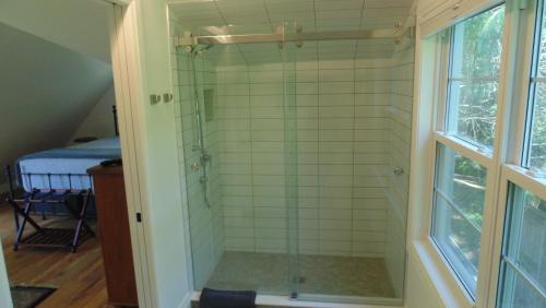 a shower with a glass door in a bathroom at Carriage House On Kent in Niagara on the Lake