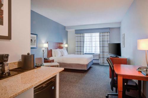 una camera d'albergo con letto e scrivania di Courtyard Raleigh Crabtree Valley a Raleigh
