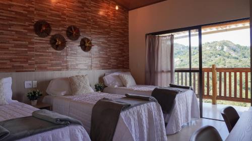 una camera da letto con due letti e un balcone di POUSADA KALUKA a Bezerros