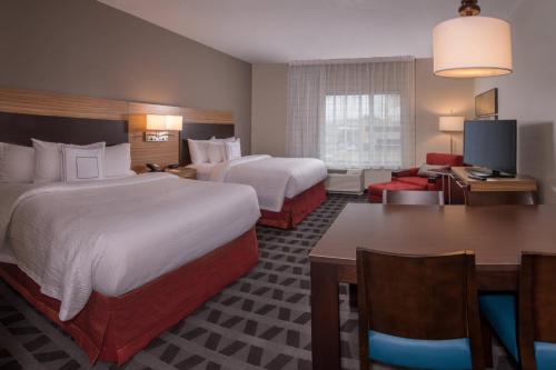 a hotel room with two beds and a living room at TownePlace Suites by Marriott Altoona in Altoona