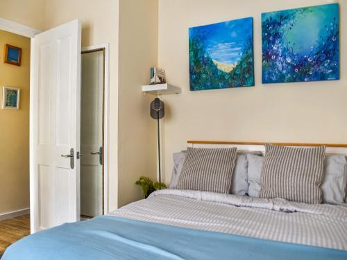 a bedroom with a bed and two paintings on the wall at The Old Sail Loft in Torquay