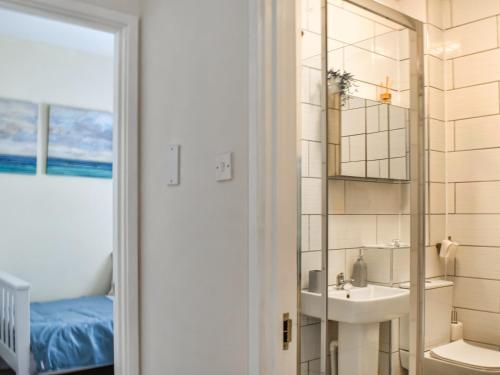 a bathroom with a sink and a mirror at The Old Sail Loft in Torquay