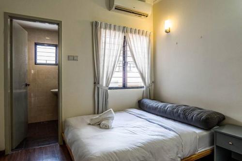 莎阿南的住宿－Double Storey Homestay at Cahaya SPK Shah Alam，一张位于房间的床,上面有大枕头