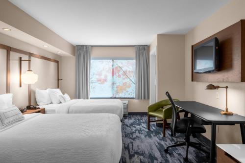 a hotel room with two beds and a desk at Fairfield by Marriott Inn & Suites Columbus Hilliard in Columbus