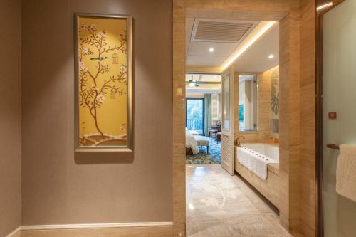 a hallway with a bathroom with a painting on the wall at Seaview Resort Xiamen in Xiamen