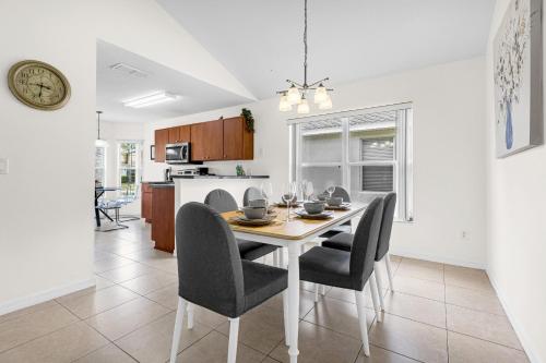 a dining room and kitchen with a table and chairs at Disney Area 4BR Home with Heated Private Pool in Kissimmee