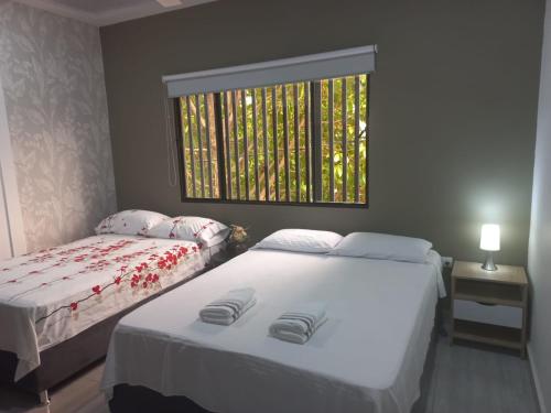 2 camas individuales en una habitación con ventana en Como en casa 2 en La Dorada