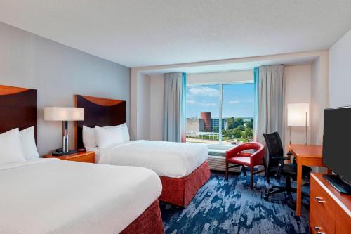 インディアナポリスにあるフェアフィールド イン スイーツ インディアナポリス ダウンタウンのベッド2台、デスク、窓が備わるホテルルームです。