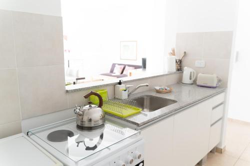 een keuken met een wastafel en een waterkoker op het fornuis bij Apartamento Tomás Jofré in San Luis