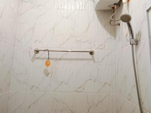 a shower in a bathroom with a white marble wall at RedDoorz Syariah At Harley Hotel Sabang in Sabong