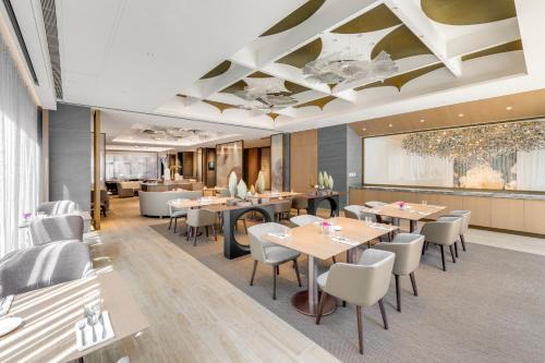 a restaurant with tables and chairs and a ceiling at DoubleTree by Hilton Taipei Zhongshan in Taipei