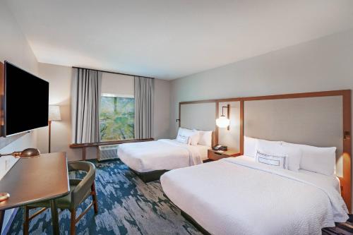 a hotel room with two beds and a desk at Fairfield Inn & Suites by Marriott Liberal in Liberal