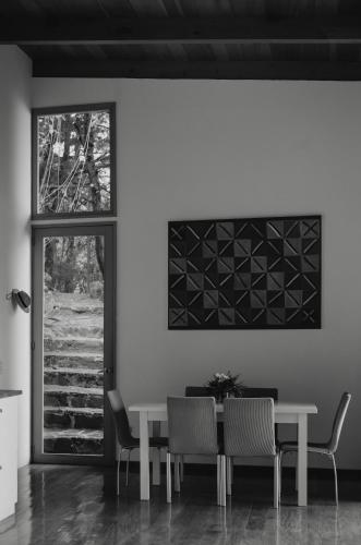 a dining room with a table and chairs and a window at Anzan Atitlan in San Marcos La Laguna