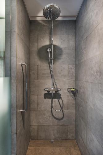 a shower with a shower head in a bathroom at Hilton Garden Inn Bali Ngurah Rai Airport in Kuta