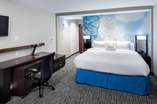 um quarto com uma cama, uma secretária e um computador em Courtyard by Marriott Dallas Plano/Richardson em Plano