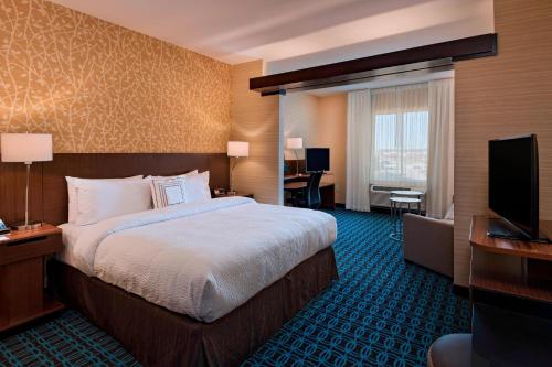 um quarto de hotel com uma cama e uma televisão de ecrã plano em Fairfield Inn & Suites by Marriott Austin Buda em Buda