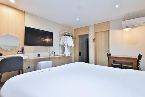 a hotel room with a bed and a mirror at The First Hotel in Changwon