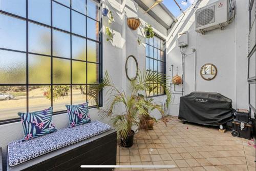 a balcony with pillows and plants in a building at 5 North Freo 2br Supercool Pad & Parking in North Fremantle