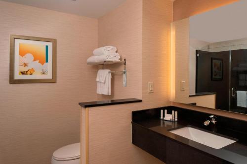 a bathroom with a sink and a toilet and a mirror at Fairfield Inn & Suites by Marriott Batesville in Batesville