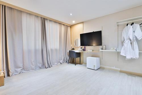 a hotel room with a desk and a television in a room at The First Hotel in Changwon