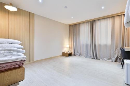 a hotel room with a bed and a window at The First Hotel in Changwon