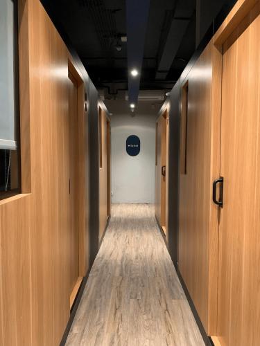 a corridor of a hallway with wooden doors and wood floors at PassGo Thamrin in Jakarta