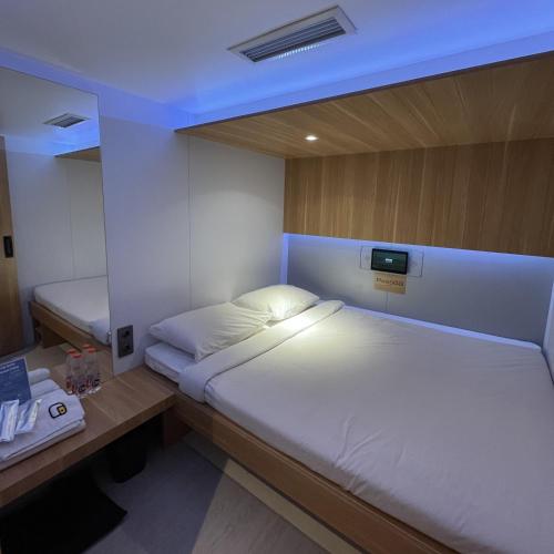 a small room with a bed and a desk with a bed sidx sidx at PassGo Thamrin in Jakarta