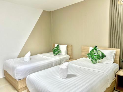 two beds in a room with white sheets at The Nine Place แจ้งสนิท in Ban Nong Bua