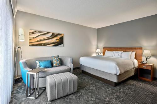 a hotel room with a bed and a chair at Courtyard Philadelphia/Langhorne in Langhorne