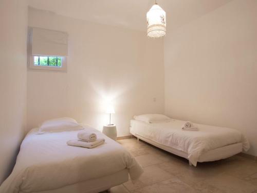 - 2 lits dans une chambre blanche avec une lampe dans l'établissement Gorgeous Apartment in Montauroux with Pool, à Montauroux