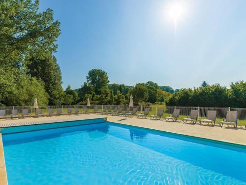une grande piscine avec des chaises dans l'établissement Holiday Home in France with Garden Terrace, à Montignac