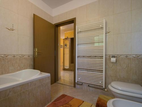 La salle de bains est pourvue d'une baignoire, de toilettes et d'un lavabo. dans l'établissement Adorable holiday home with private pool and terrace with barbecue!, à Antovo