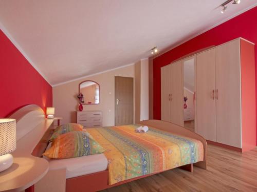 - une chambre avec un lit et un mur rouge dans l'établissement Adorable holiday home with private pool and terrace with barbecue!, à Antovo