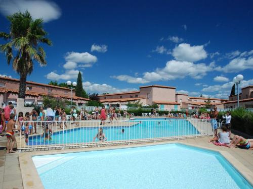 un groupe de personnes debout autour d'une piscine dans l'établissement Holiday Home in France with Garden Terrace, à Saint Cyprien Plage