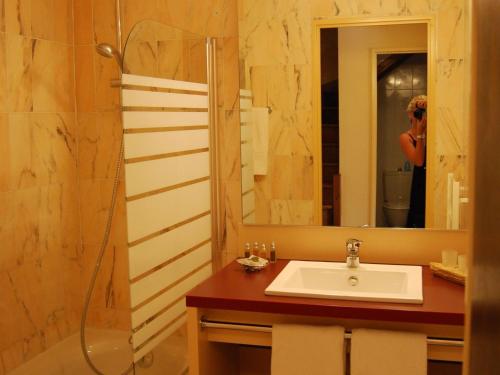 une femme prenant une photo d'une salle de bains avec lavabo et douche dans l'établissement Holiday Home in France with Garden Terrace, à Saint Cyprien Plage