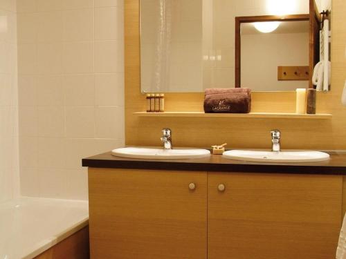 une salle de bain avec deux lavabos, un miroir et une baignoire dans l'établissement Studio in Brides-les-Bains for 4 People, à Brides-les-Bains