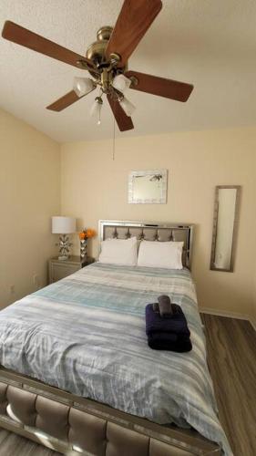 a bedroom with a bed with a ceiling fan at Charming Vacation House 3Be 2Ba Solar heated pool in Tampa