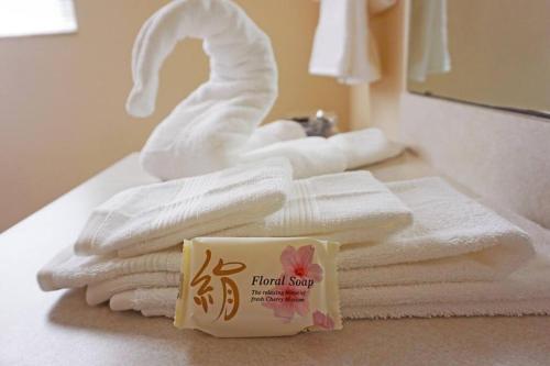 a pile of towels on a bathroom counter with a towel swan at Charming Vacation House 3Be 2Ba Solar heated pool in Tampa