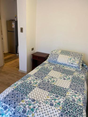 a bedroom with a bed with a quilt on it at Arriendo Departamento con 2 habitaciones 1 baño en Concepción cerca de Aeropuerto in Concepción