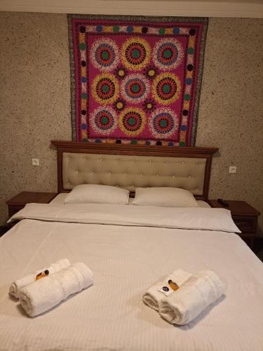 Una cama con dos toallas encima. en Гостевой дом AL XALIL en Samarcanda