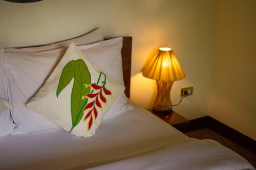 a bed with two pillows on it with a lamp at Cadlao Resort and Restaurant in El Nido