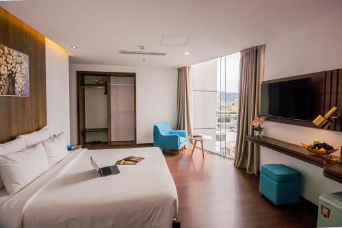 a hotel room with a large bed and a large window at Gold Central Hotel by Haviland in Da Nang