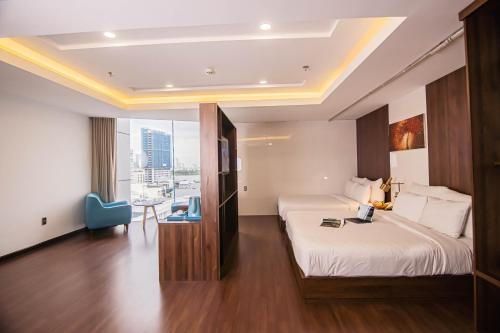 a hotel room with two beds and a table at Gold Central Hotel by Haviland in Da Nang