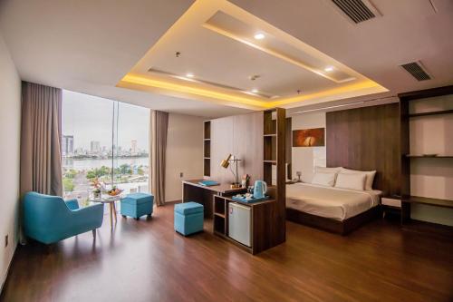 a hotel room with a bed and a desk and a table at Gold Hotel Da Nang by Haviland in Danang