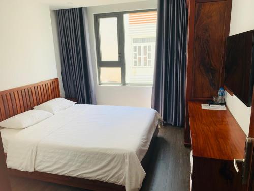a hotel room with a bed and a window at Luu Gia Hotel in Nha Trang