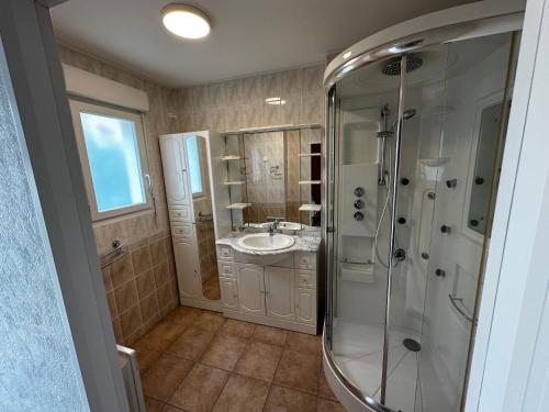 une salle de bain avec douche et lavabo dans l'établissement Villa Les Mathes, aux Mathes
