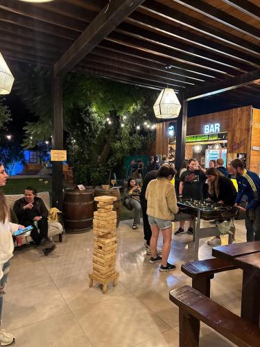 a group of people standing around a bar with tables at Gorilla Hostel in Mendoza