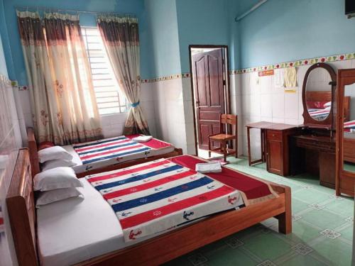 a bedroom with two beds and a sink and a mirror at Ngoc Mai 2 Hotel in Can Tho
