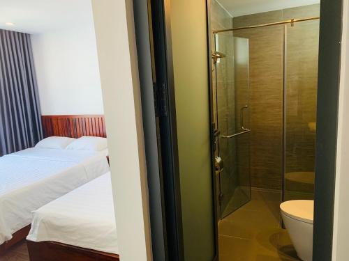 een badkamer met een douche, een bed en een toilet bij Luu Gia Hotel in Nha Trang